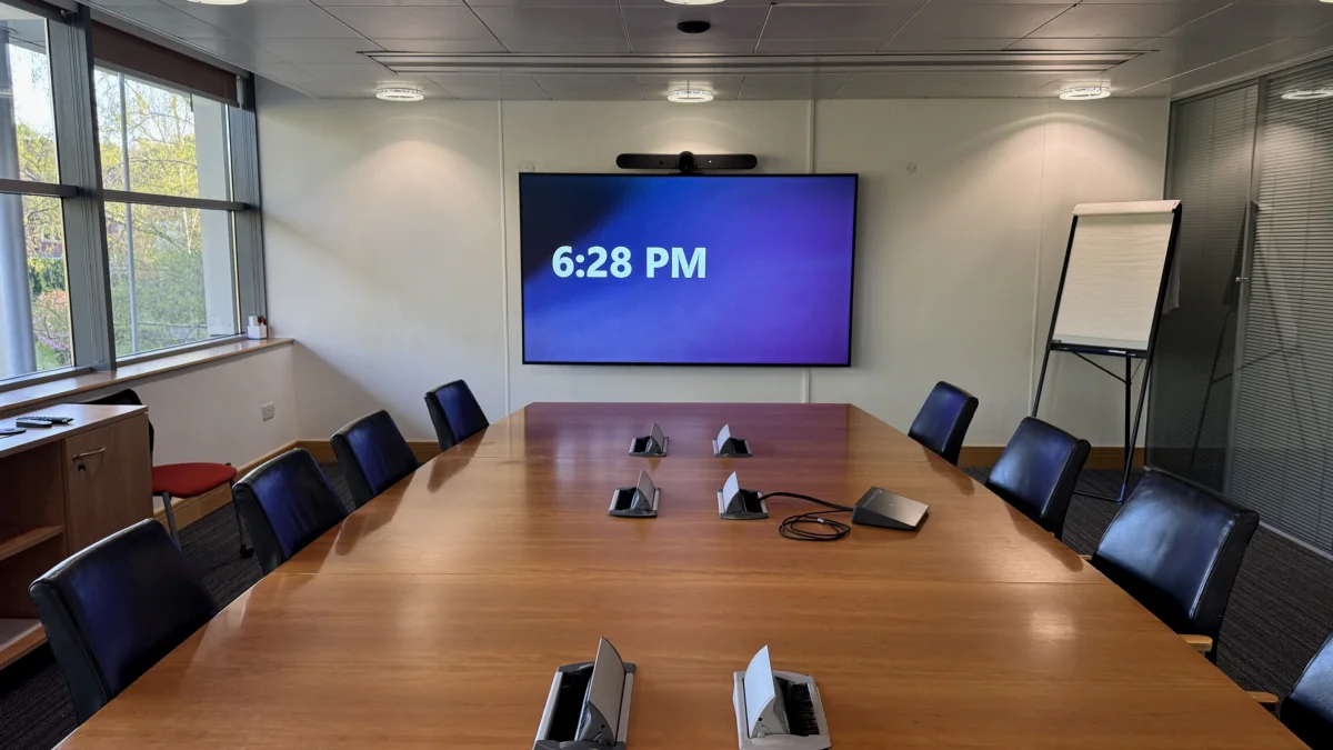 A small meeting room with wall display and conferencing bar installed by AV Xpert