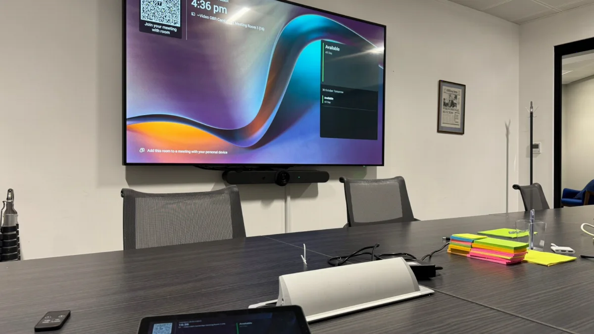A boardroom table with touch panel and wall displays installed by AV Xpert