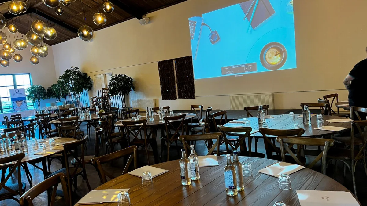 A hotel function room with a projection screen installed by AV Xpert, set for a conference