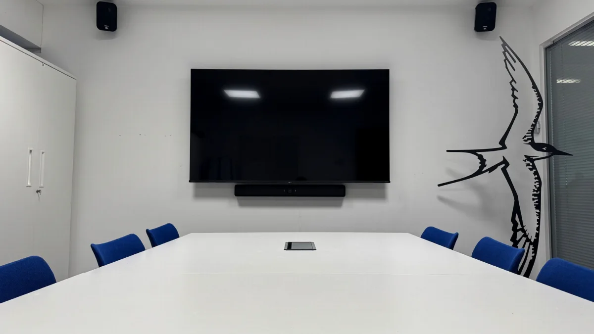 A meeting room with a wall display, soundbar and ceiling speakers installed by AV Xpert