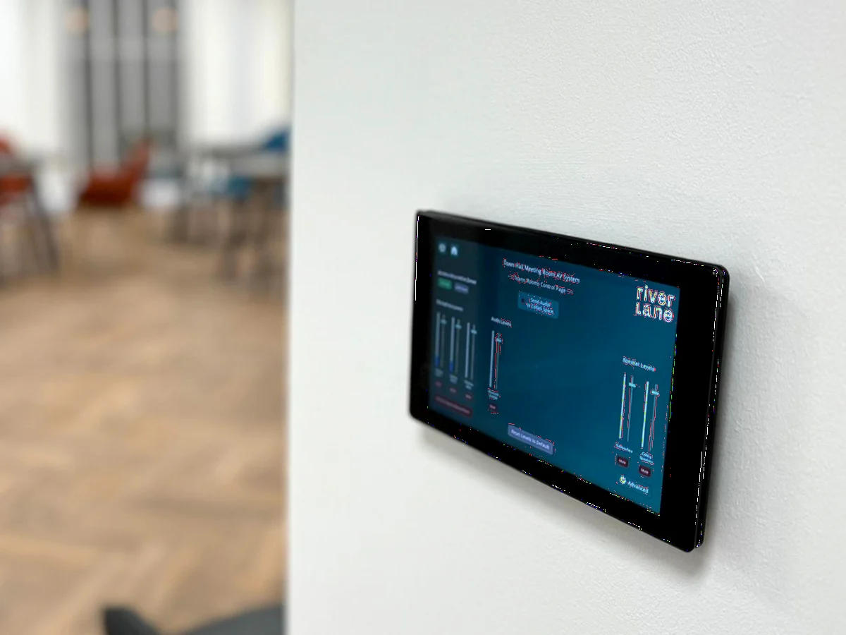A wall-mounted touch panel with a custom Riverlane-branded interface