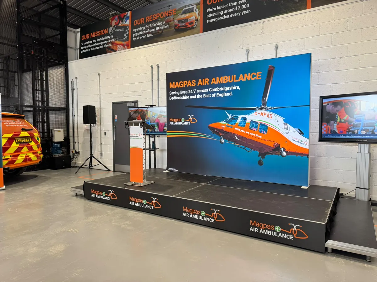 A stage with screens set up by AV Xpert for a Magpas Air Ambulance event
