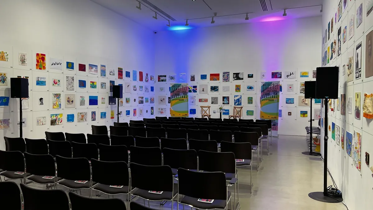 A room set up with speakers and uplighting for a community event
