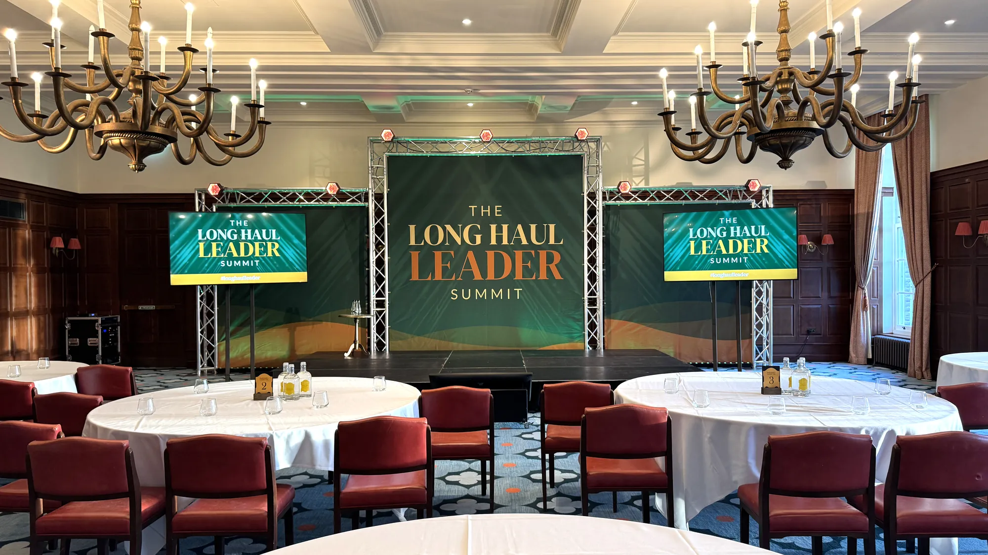 A conference stage with screens and lectern set up by AV Xpert