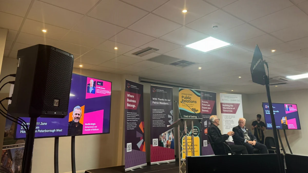 A PA speaker on a stand beside the stage at a business conference