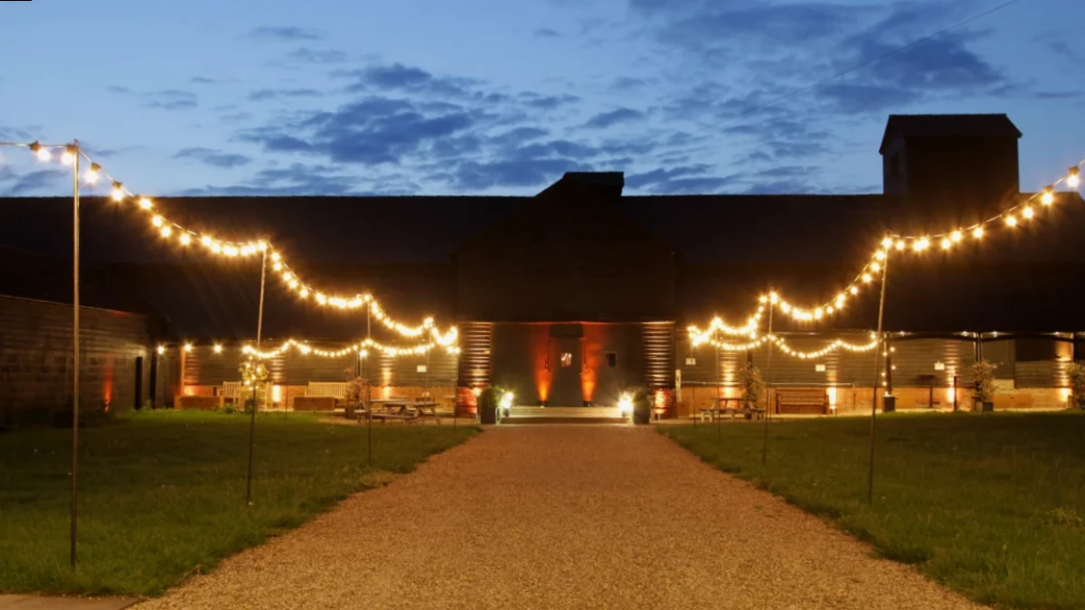 Festoon lighting strung across the courtyard at Childerley at dusk