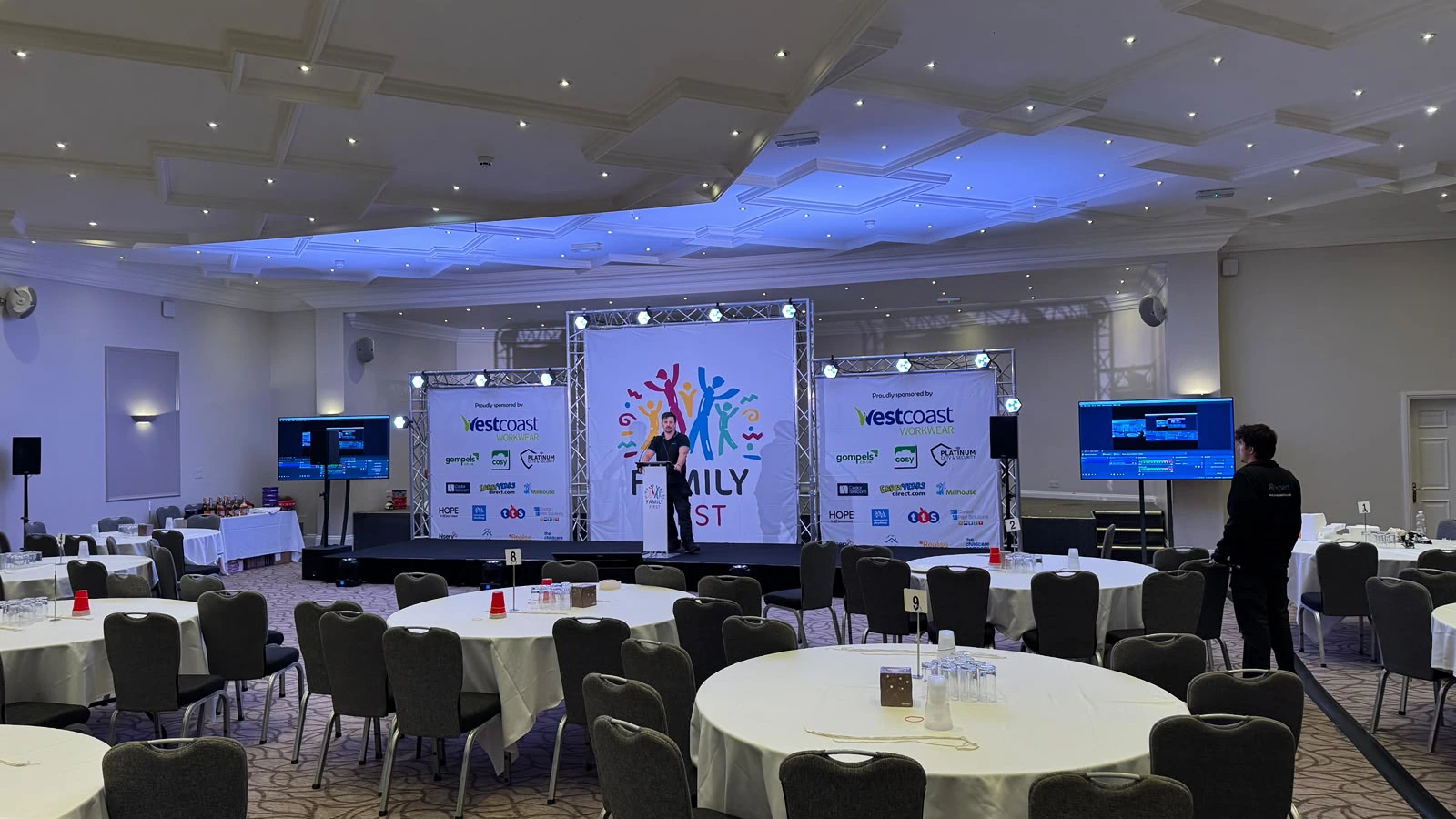 Display screens either side of a branded stage in a hotel ballroom
