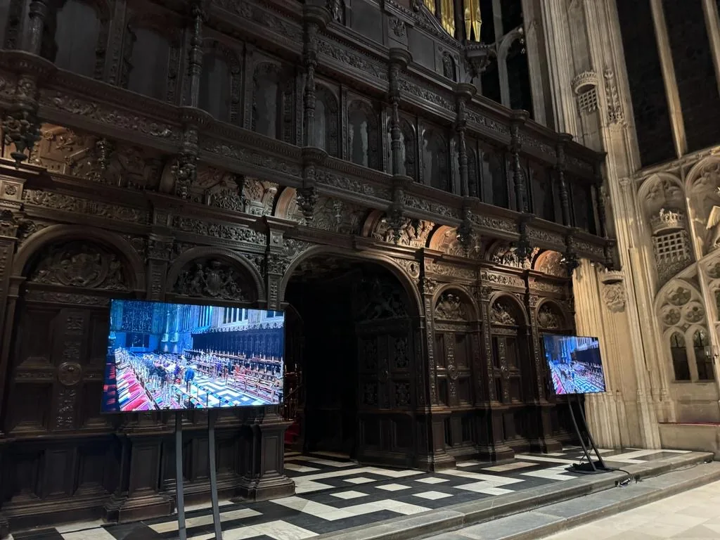 Screens showing a live feed of the service inside King’s College Chapel, Cambridge