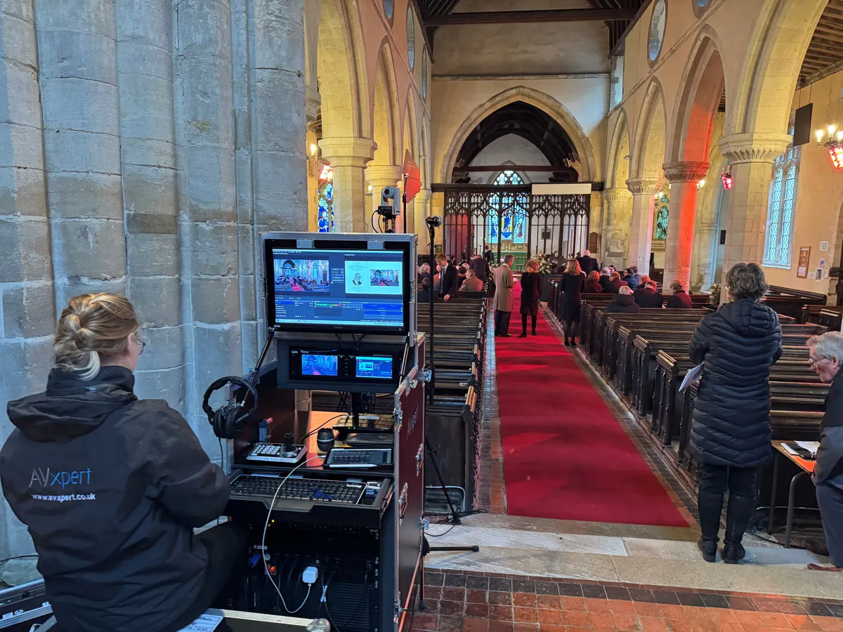 An AV Xpert technician at the live streaming desk beside the aisle of a church