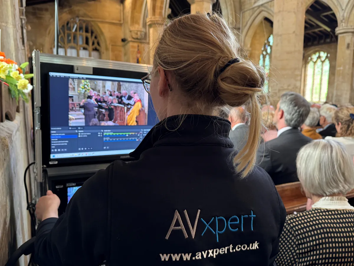 An AV Xpert technician streaming a church service, the choir on the monitor