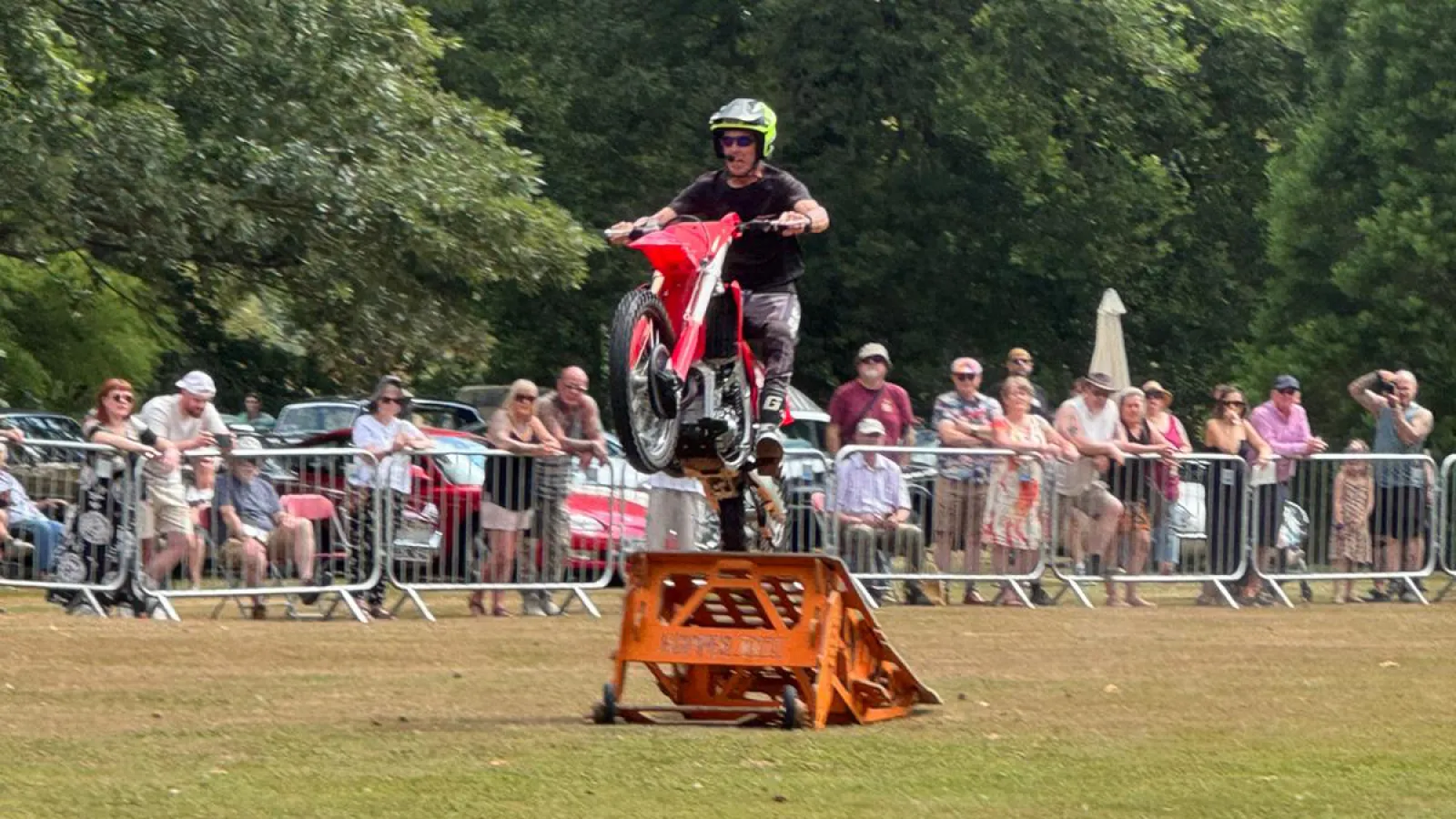 A stunt rider in the arena at the Kimbolton Classic Car Show, with the crowd lining the barriers