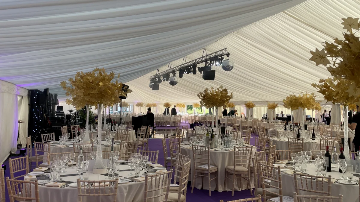 A marquee set for a celebration dinner, with a lighting rig from AV Xpert