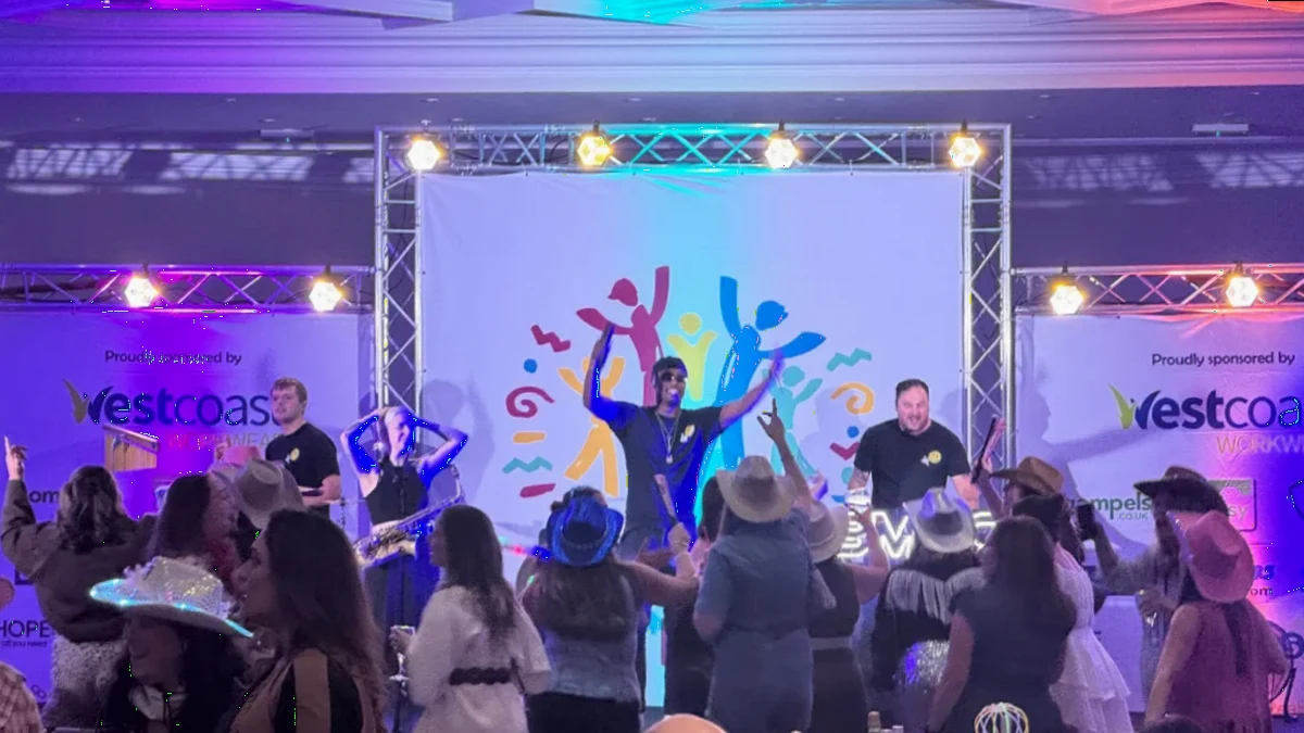 Guests dancing to a live band at a celebration at Whittlebury Park, with staging and lighting from AV Xpert